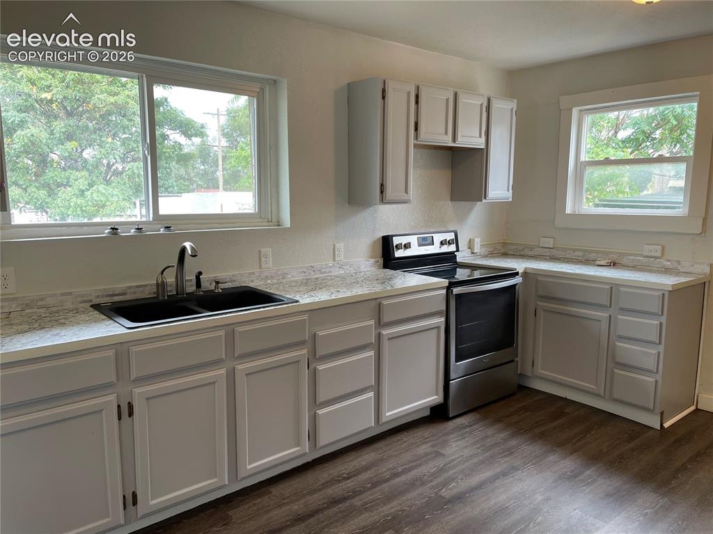 Image 10 of 16: Kitchen featuring light grey cabinetry with brushed nickel hardware, white