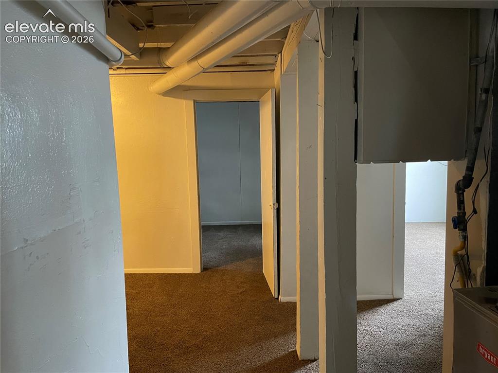 Image 14 of 16: Finished basement space featuring brown carpeting, white painted walls, exp