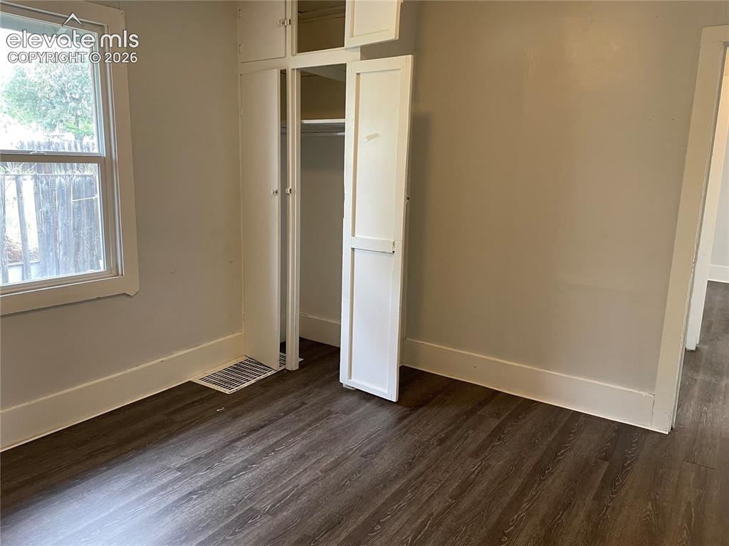 Image 5 of 16: Room featuring wood-finish flooring, light-toned walls, and white trim