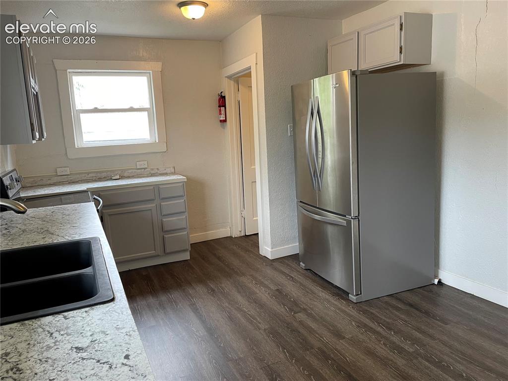Image 9 of 16: Kitchen featuring wood-finish flooring, light grey cabinetry, a stainless s