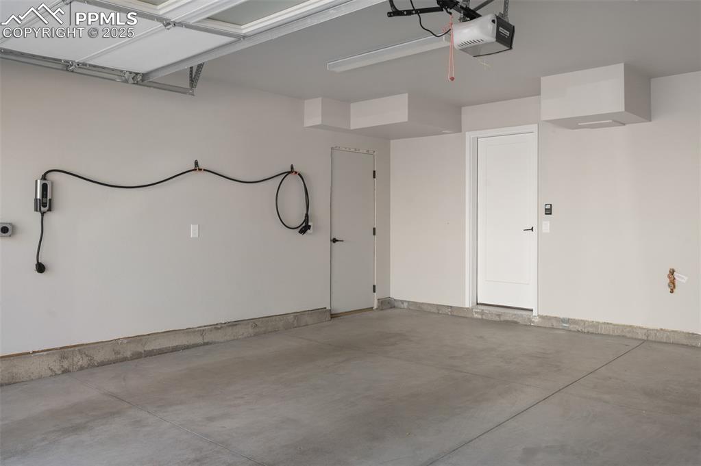 Image 20 of 27: Fully insulated and drywalled garage with EV charging station plus hot and