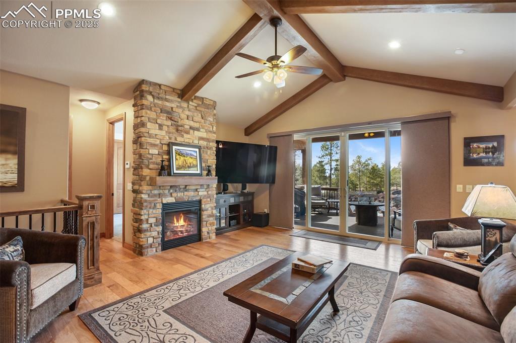 Image 18 of 48: Living area with lofted ceiling with beams, light wood-style flooring, ceil