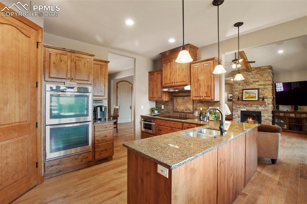Image 20 of 48: Kitchen featuring black electric stovetop, under cabinet range hood, double