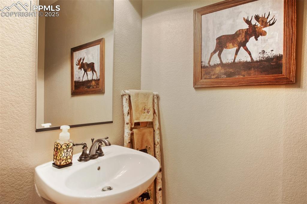 Image 25 of 48: Half-Bathroom with a textured wall and a sink