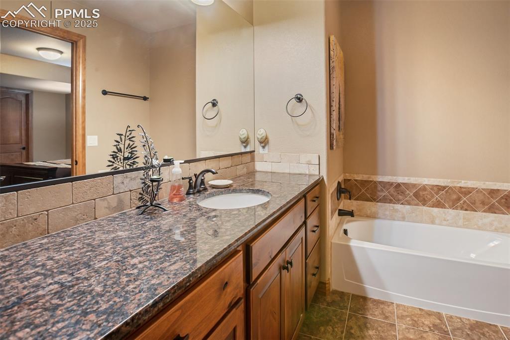 Image 27 of 44: Full bathroom in lower level connected to back lower bedroom