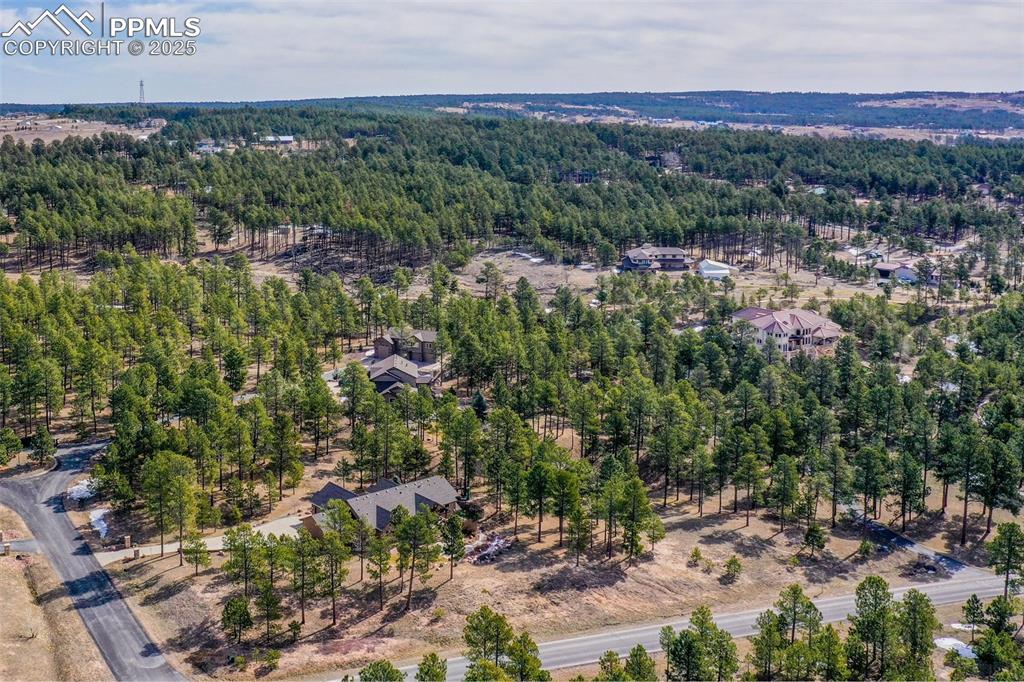 Image 4 of 48: Aerial view featuring a wooded view