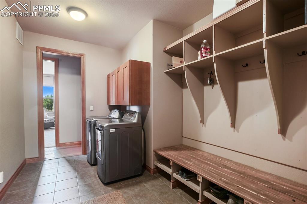 Image 44 of 48: Clothes washing area featuring visible vents, washer and dryer, cabinet spa