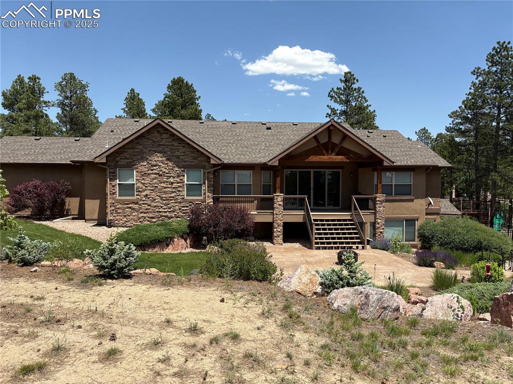 Image 5 of 48: View of front facade featuring stairs, stucco siding, stone siding, a woode