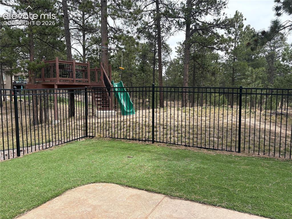 Image 9 of 44: View from lower level in dog run and little tree house with zip line