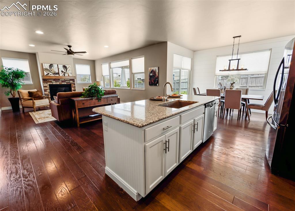 Image 12 of 50: Kitchen island featuring a granite countertop, undermount sink, and white b