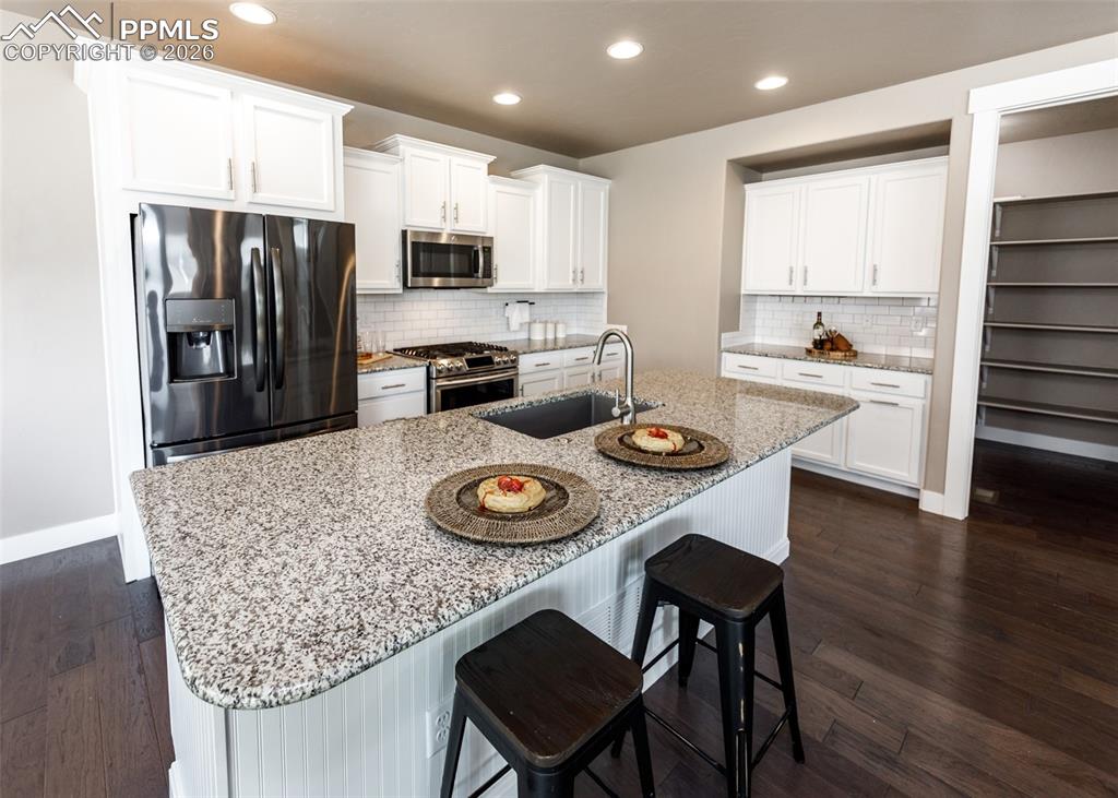 Image 16 of 50: Kitchen featuring an expansive island with a granite countertop and integra