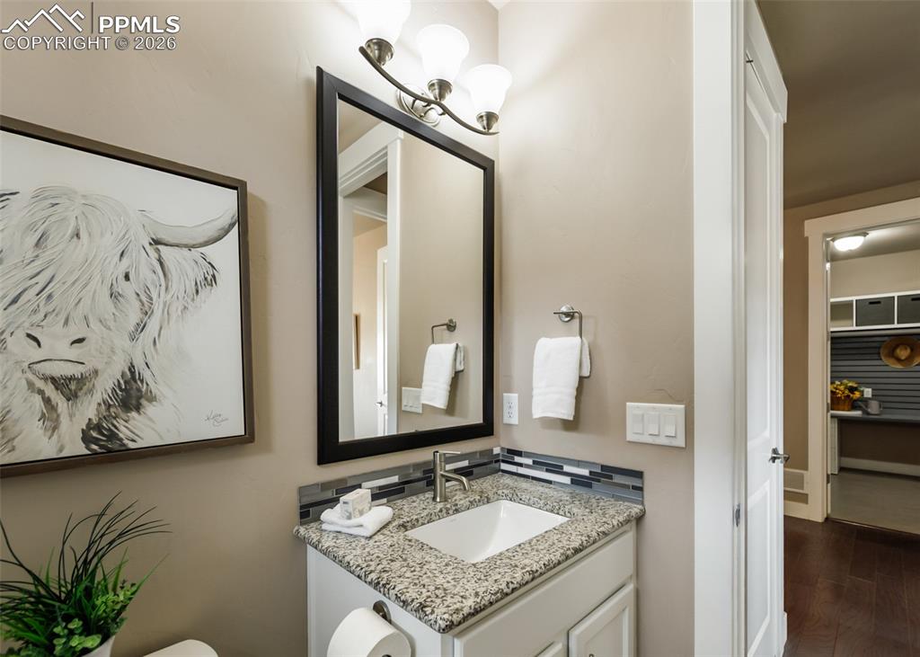 Image 24 of 50: Bathroom vanity featuring a granite countertop, undermount sink, and a mosa