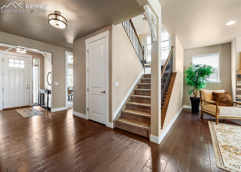 Image 29 of 50: Expansive entryway featuring wood-finish flooring, a carpeted staircase wit