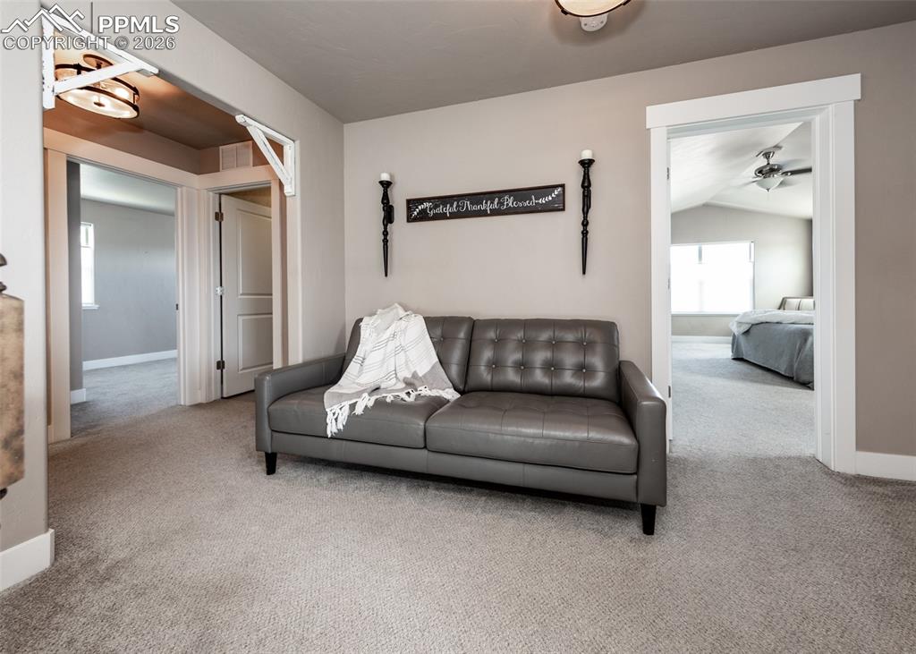 Image 31 of 50: Carpeted landing area featuring a neutral color palette, white trim, and a
