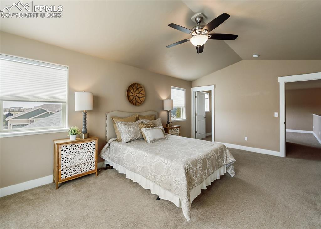Image 32 of 50: Carpeted room featuring a vaulted ceiling and a ceiling fan with integrated