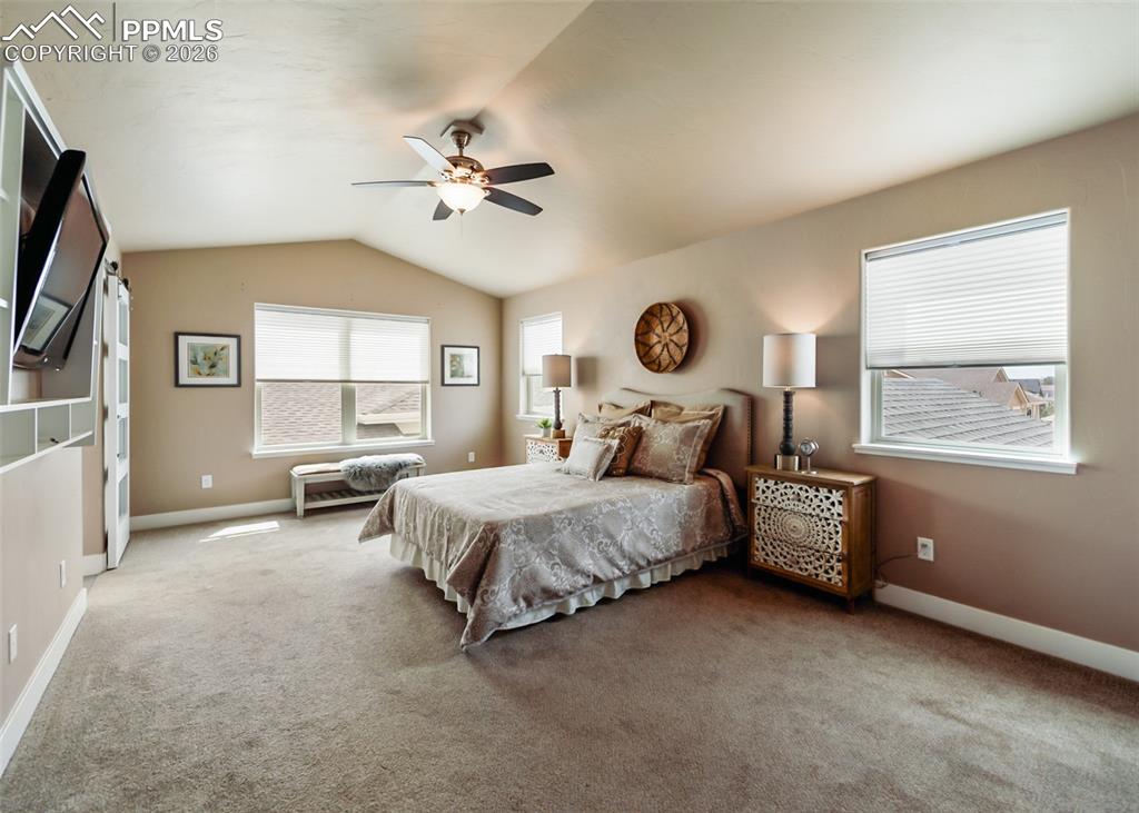 Image 33 of 50: Carpeted interior space featuring a vaulted ceiling with a ceiling fan, mul