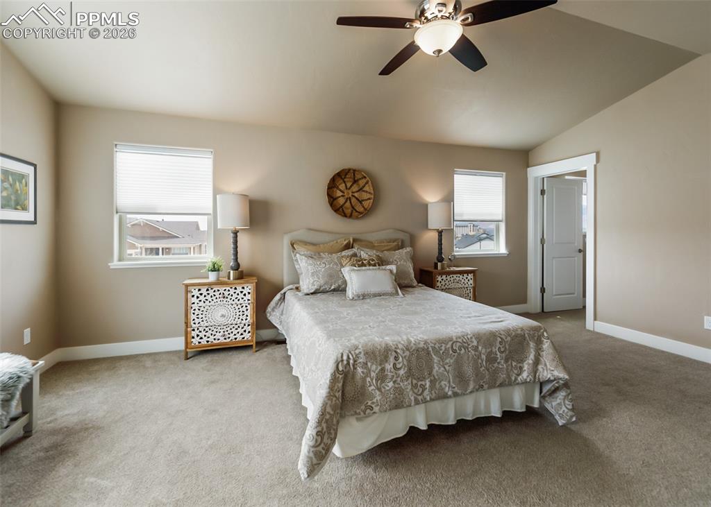 Image 34 of 50: Carpeted room with vaulted ceilings and a ceiling fan