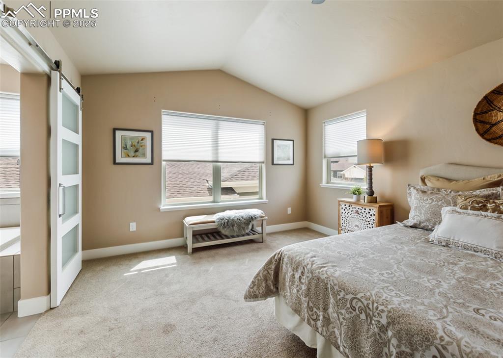 Image 36 of 50: Vaulted ceiling room featuring light tan walls, two windows with blinds, an