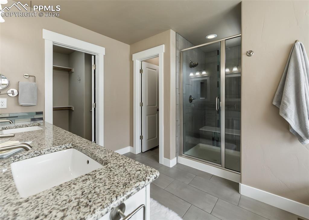 Image 39 of 50: Bathroom featuring a granite countertop vanity with an integrated sink, a g