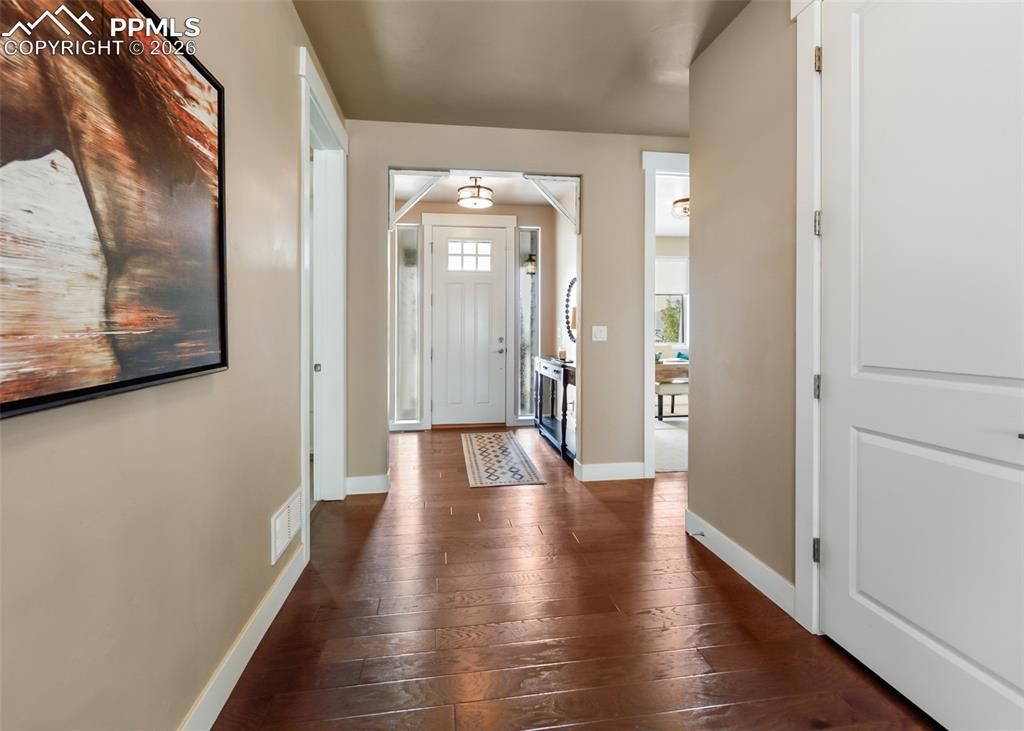 Image 4 of 50: Entryway featuring rich wood-finish flooring, neutral-toned walls, and whit