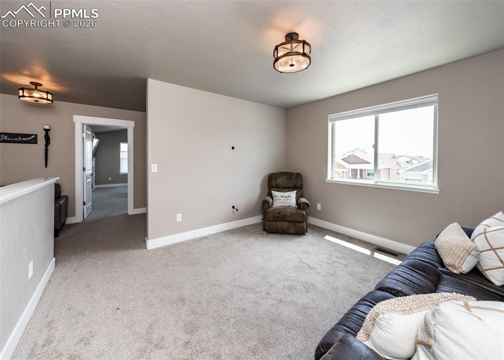 Image 41 of 50: Upper-level room featuring neutral-toned carpet, a large window, and recess