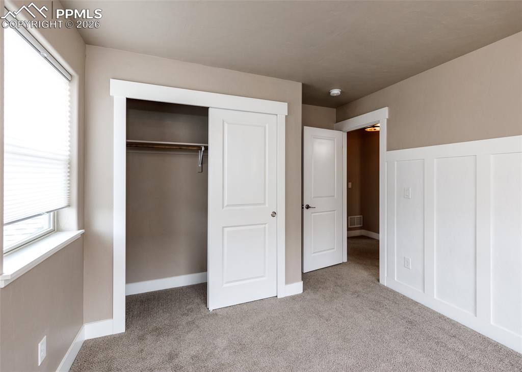 Image 44 of 50: Carpeted room featuring a built-in closet with sliding doors, a large windo
