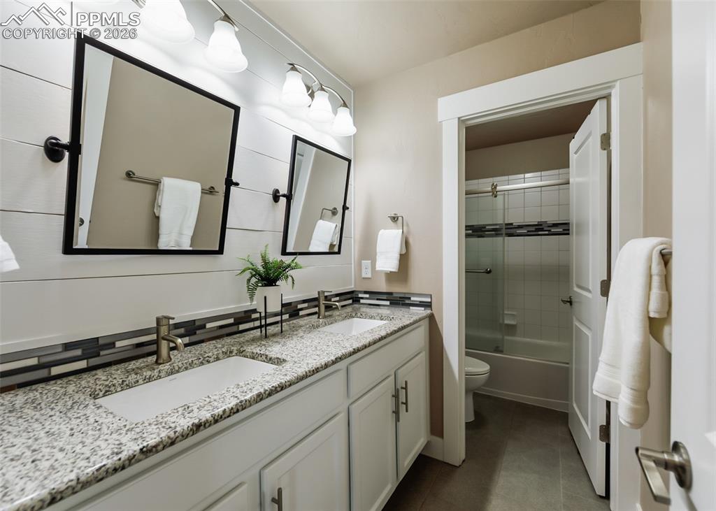 Image 46 of 50: Double vanity with granite countertop and undermount sinks, featuring dual
