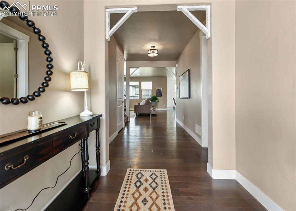 Image 5 of 50: Hallway featuring wood-finish flooring, light-toned walls, white baseboards