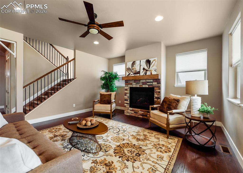 Image 7 of 50: Living room featuring a stacked stone and wood mantle fireplace, wood-finis