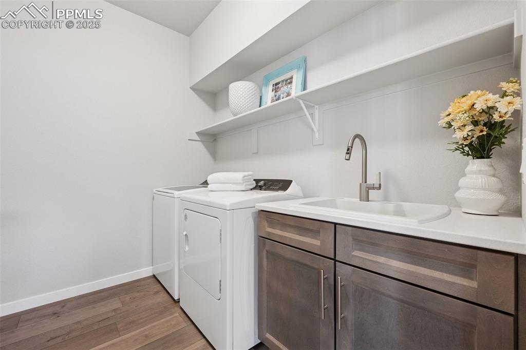 Image 26 of 45: Charming main level laundry with counter and sink!