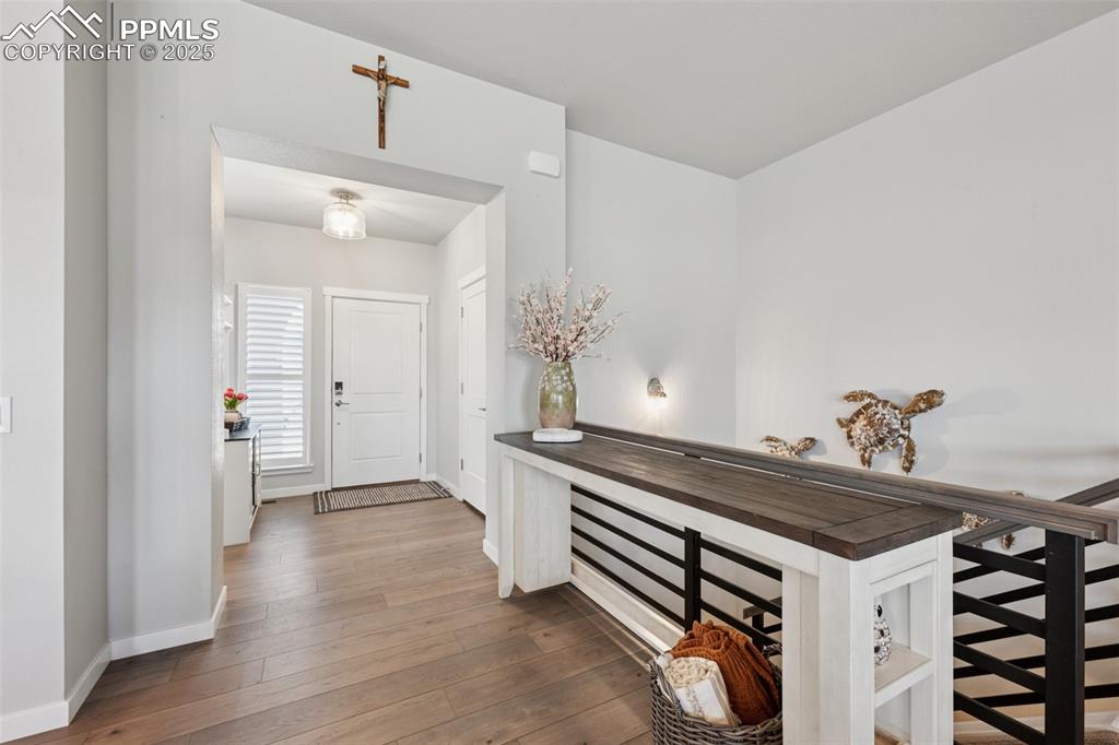 Image 7 of 45: Welcoming entry with plank flooring and upgraded lighting!