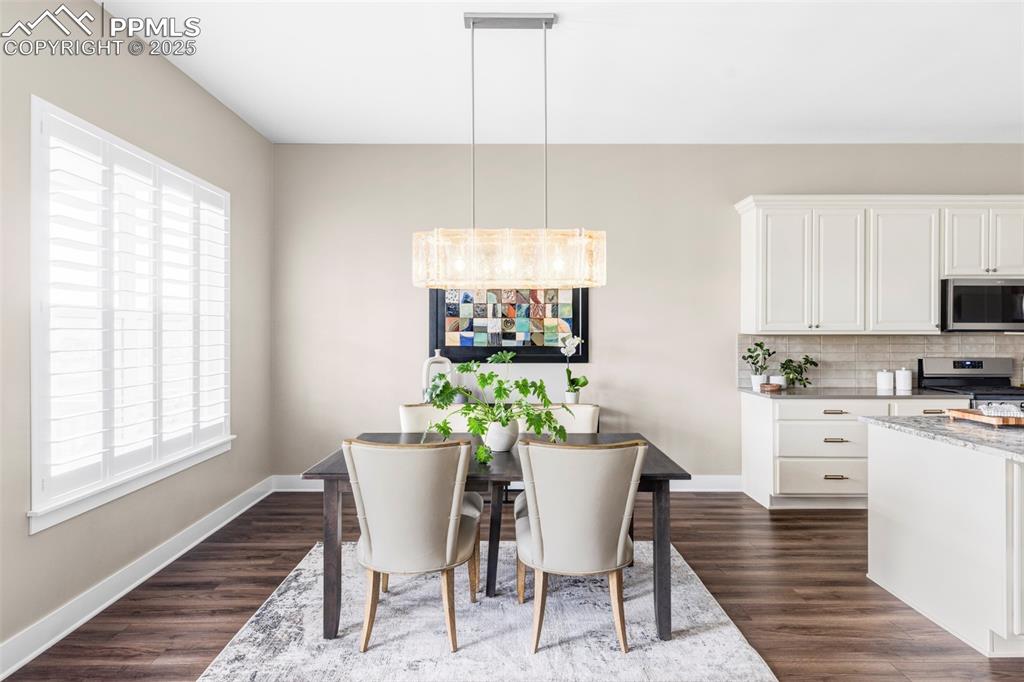 Image 12 of 44: Dining room featuring dark wood-type flooring