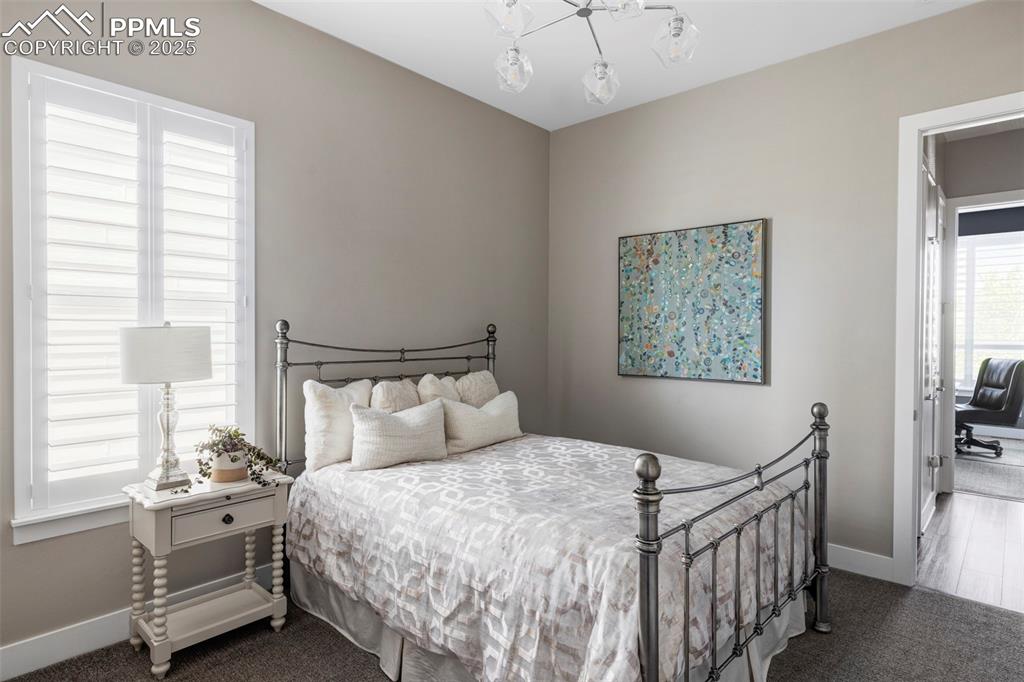 Image 29 of 44: Carpeted bedroom featuring baseboards and a chandelier