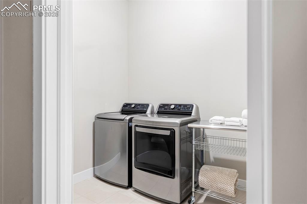 Image 34 of 44: Laundry room with separate washer and dryer and light tile patterned floori