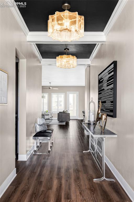 Image 4 of 44: Hallway featuring dark wood-style flooring, ornamental molding, and a chand
