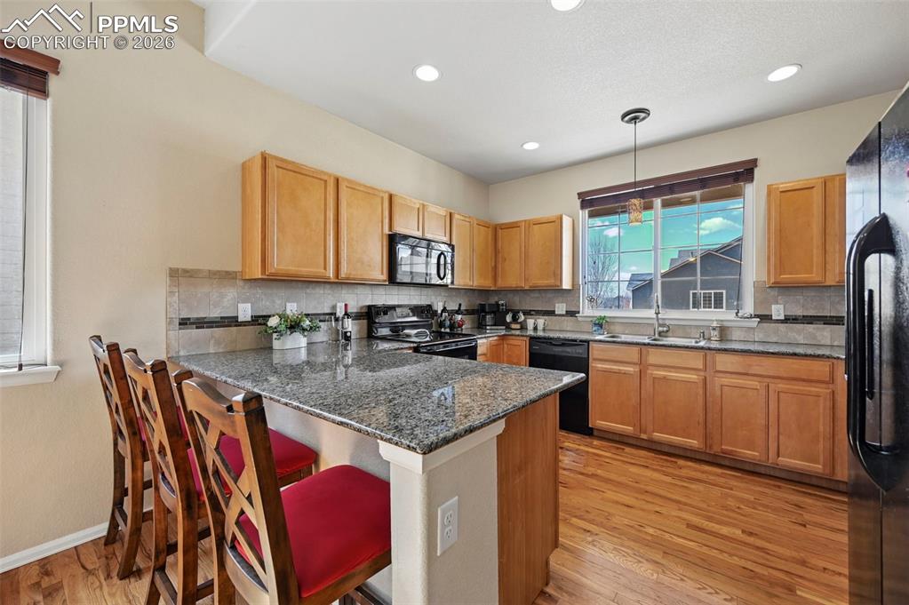 Image 10 of 44: Stunning open kitchen featuring granite countertops, a large breakfast bar,