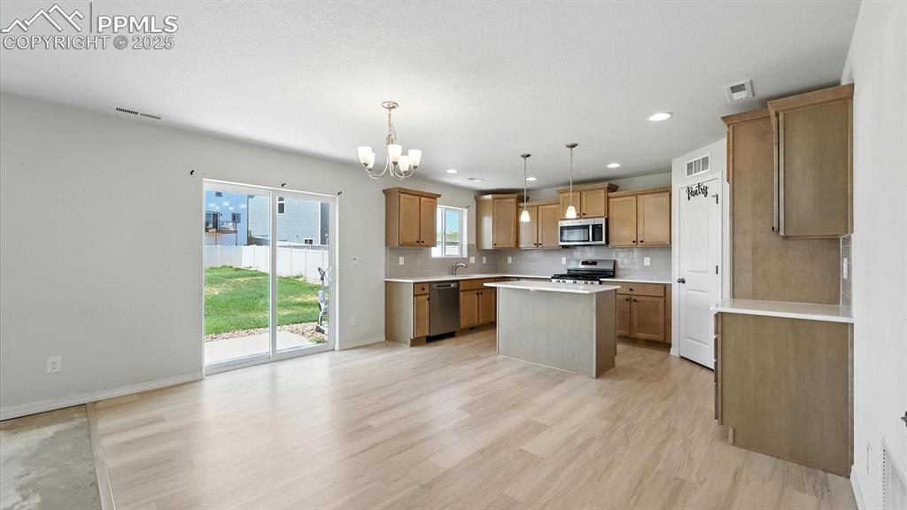 Image 14 of 50: Walk out from the Dining Area and Kitchen to the background patio.