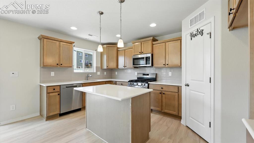 Image 19 of 50: Island Kitchen with breakfast bar, pantry, and stainless steel appliances i
