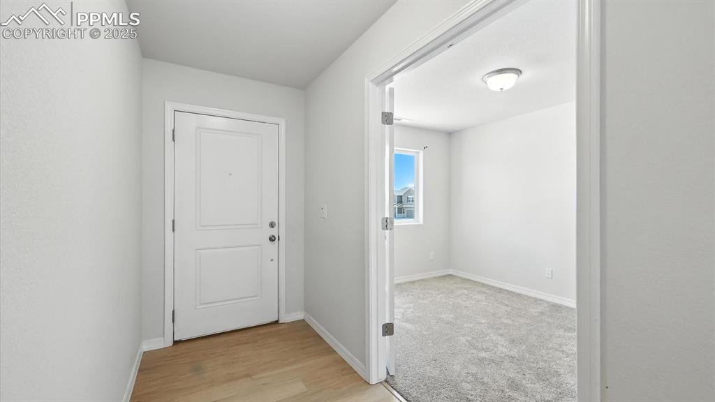 Image 4 of 50: Front Entry with LVP floor and French doors into the Main Level Office.