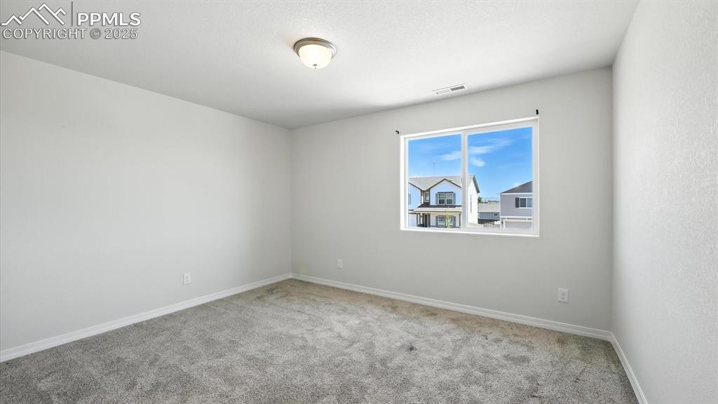 Image 40 of 50: Upper Level Bedroom #2 with neutral carpet.