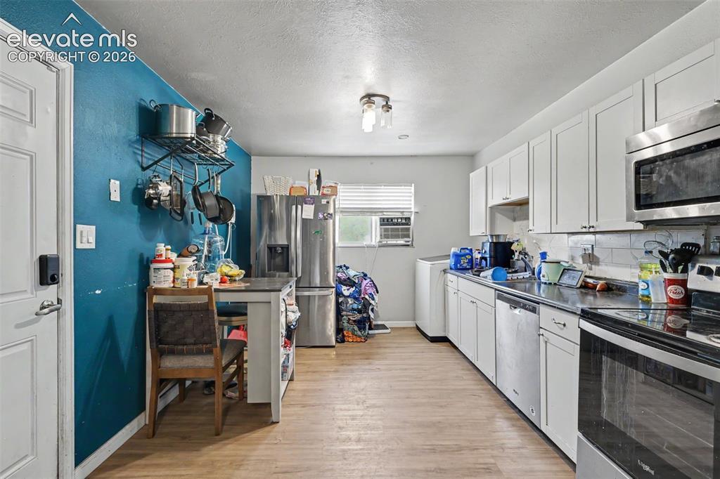 Image 7 of 25: The Kitchen comes equipped with a Refrigerator, Microwave, Dishwasher, Rang