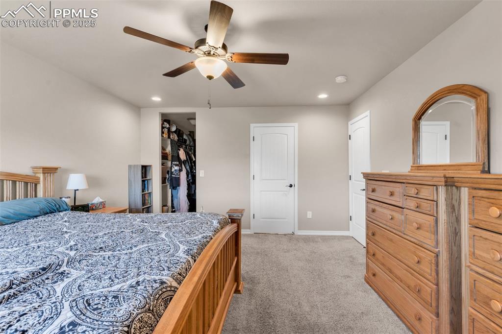 Image 16 of 37: Bedroom featuring recessed lighting, light carpet, a walk in closet, and a