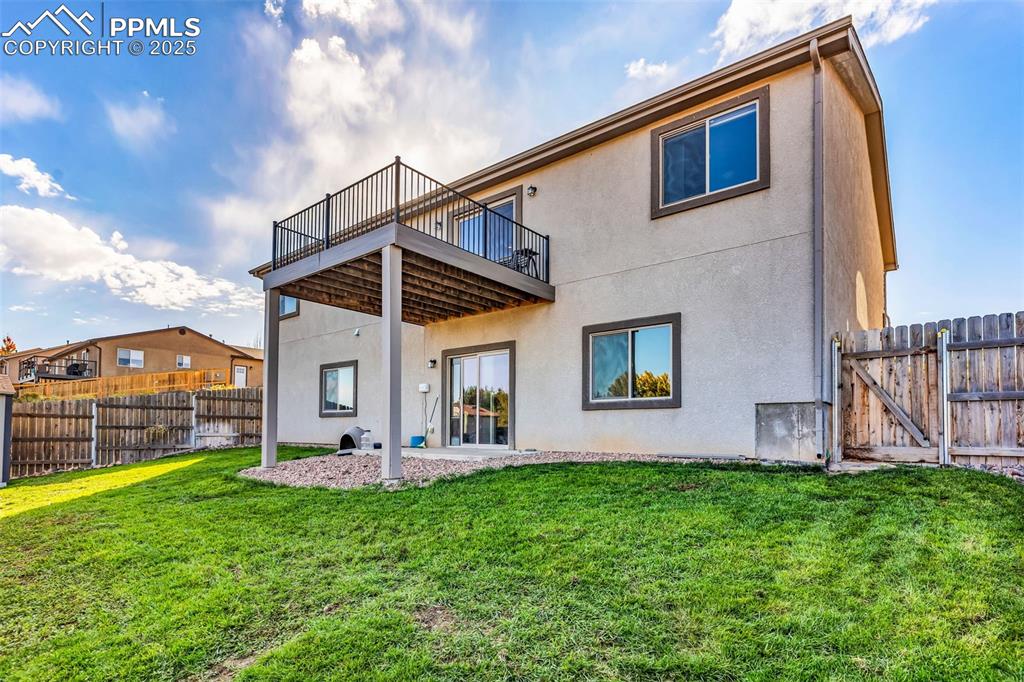 Image 37 of 37: Back of property with a patio, a fenced backyard, stucco siding, and a gate