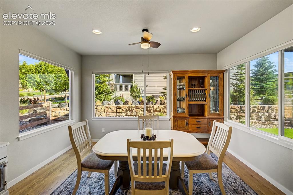 Image 16 of 45: Light-filled dining area framed by expansive windows, creating a bright and
