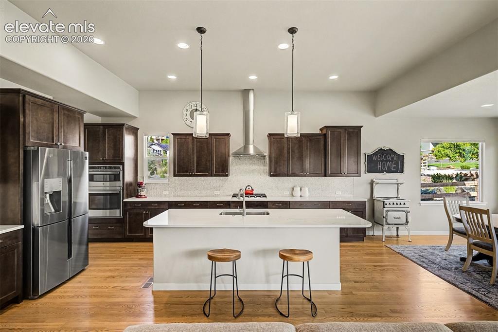 Image 18 of 45: Gourmet kitchen features rich cabinetry, quartz countertops, premium stainl