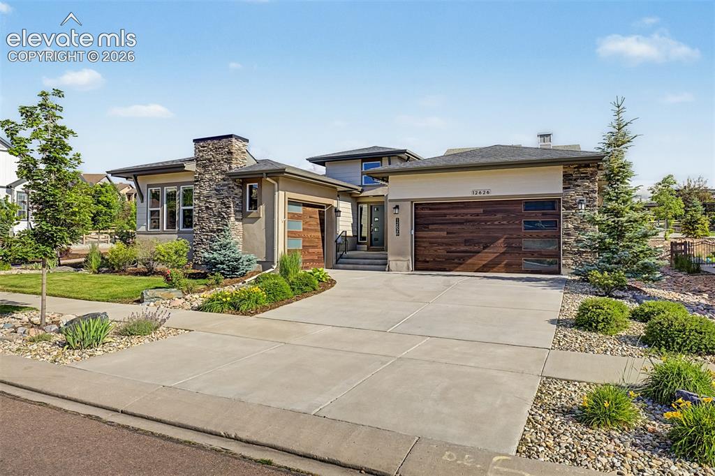 Image 2 of 45: Beautiful curb appeal with attractive landscaping, a spacious three-car gar