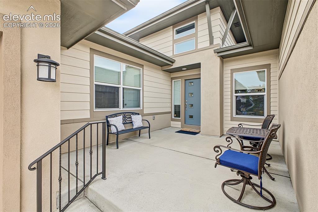 Image 3 of 45: A welcoming front courtyard creates an inviting outdoor space to relax, enj