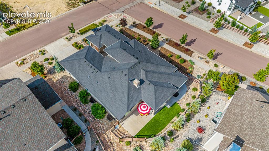 Image 43 of 45: Asphalt shingle roofing, concrete patio, artificial turf, and extensive roc
