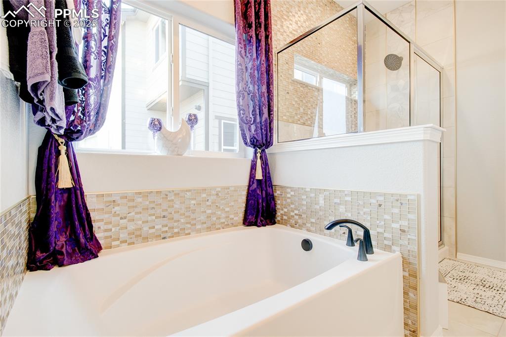 Image 21 of 34: Full bathroom with a shower stall, a garden tub, and tile patterned floors