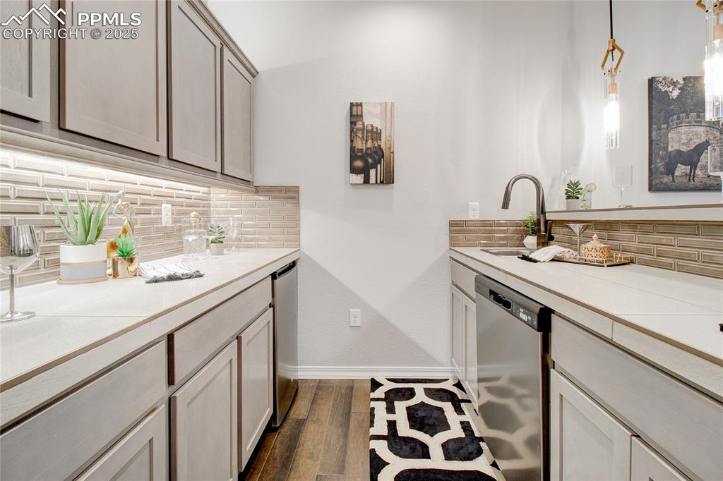 Image 30 of 34: Kitchen featuring tasteful backsplash, stainless steel dishwasher, hanging